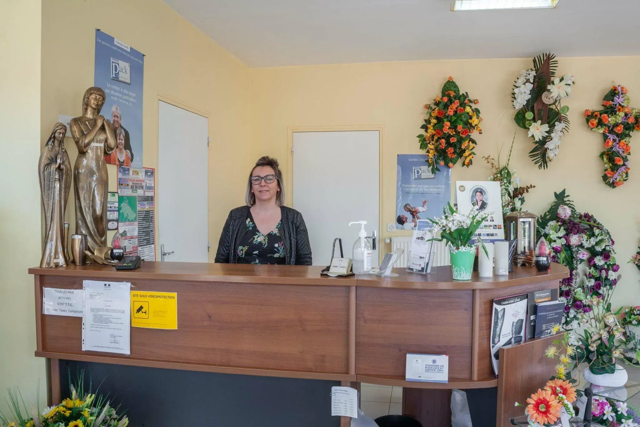 Accueil des familles par une conseillère funéraire au comptoir de l'agence.
