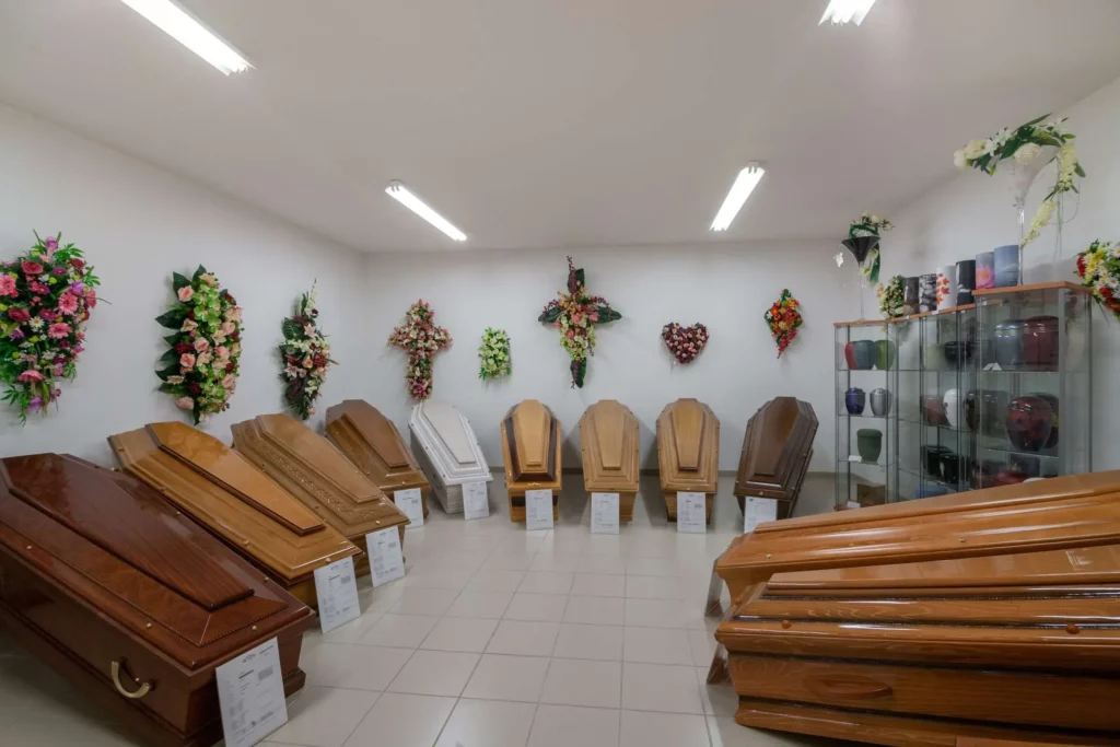 Salle d'exposition présentant une sélection de cercueils en bois et urnes.
