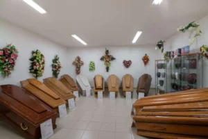 Salle d'exposition présentant une sélection de cercueils en bois et urnes.