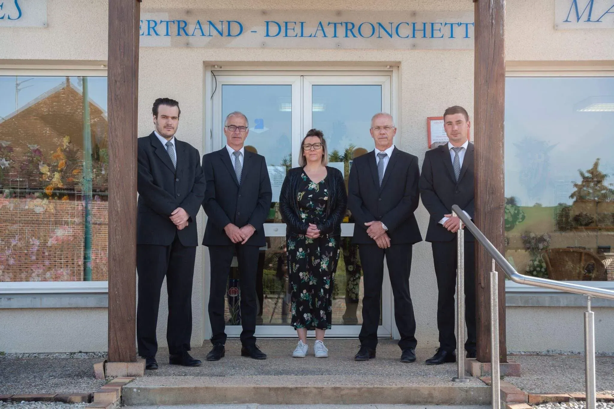 Équipe des Pompes Funèbres Bertrand-Delatronchette posant devant l'entrée de l'agence.